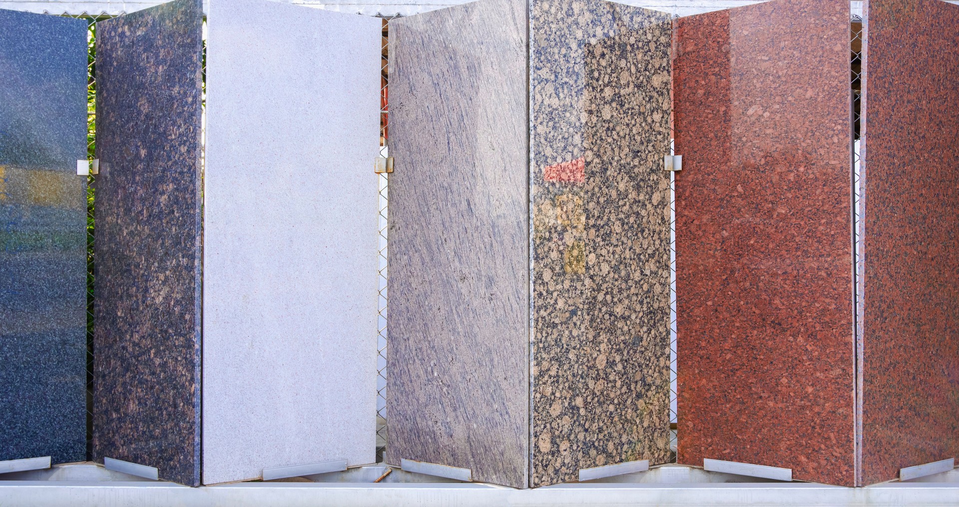 Various marble slabs sample on showing rack display stand in zig zag pattern for sale in front of building materials supply store, front view