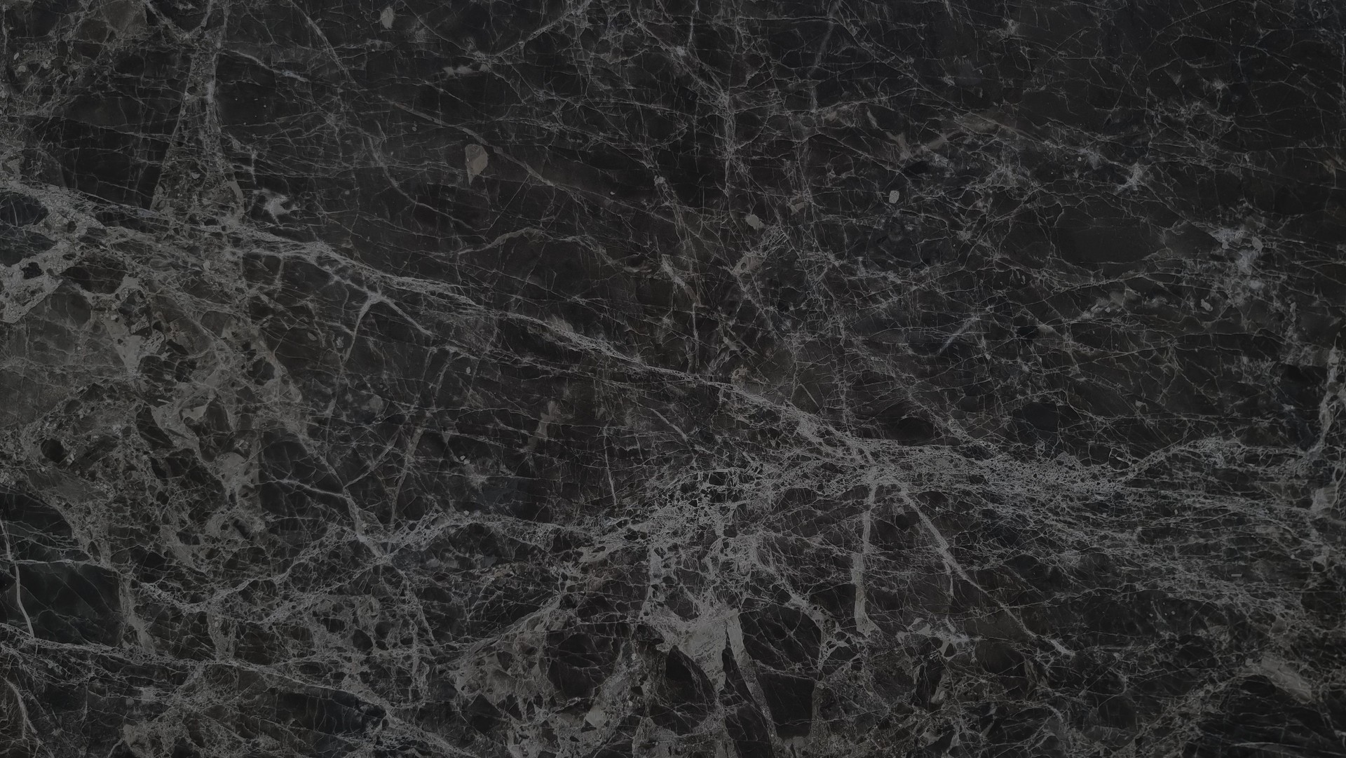 close-up view of a black emperador marble surface with a captivating pattern of intricate grey veins and subtle variations in shade, creating a visually rich.